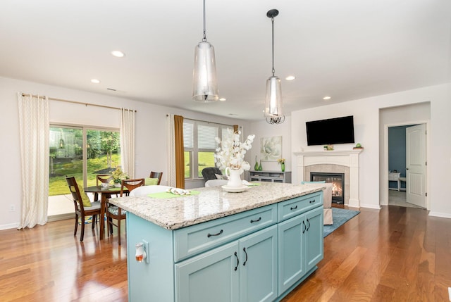 9733 Cobalt Way, Union, KY 41091 - kitchen with blue cabinets, wood finished floors, recessed lighting, a tiled fireplace, and a kitchen island
