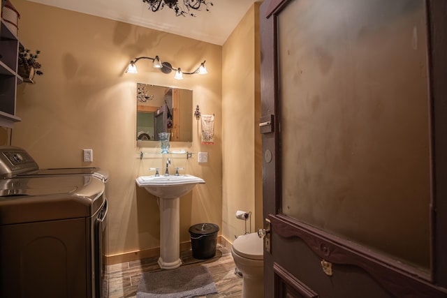 1145 Hillandale Dr, Sanders, KY 41083 - bathroom featuring washer and clothes dryer, toilet, baseboards, and a sink