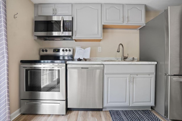 6161 Ridgewood Ct, Florence, KY 41042 - kitchen with appliances with stainless steel finishes, light wood finished floors, and white cabinets