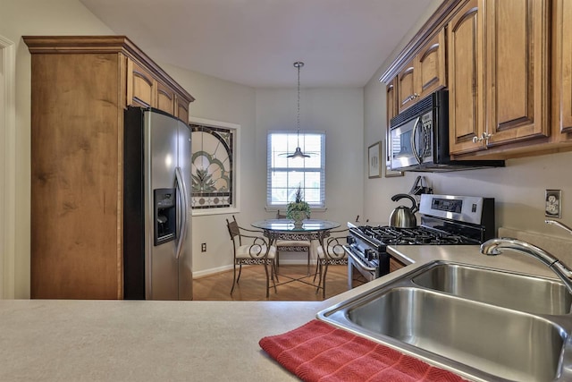 2754 Mansion Pl, Crestview Hills, KY 41017 - kitchen with stainless steel appliances, a sink, brown cabinets, and pendant lighting