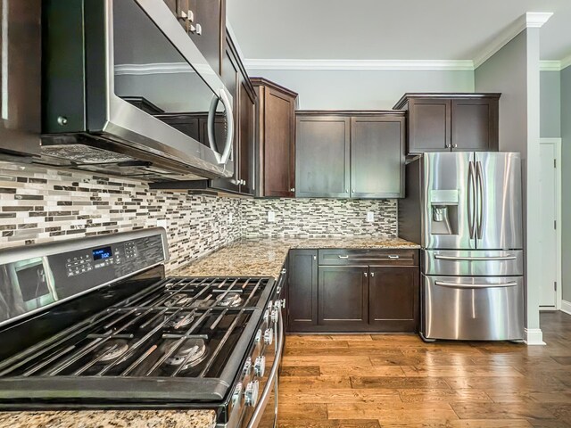 2563 Twin Hills Ct, Union, KY 41091 - kitchen featuring appliances with stainless steel finishes, ornamental molding, dark brown cabinetry, light stone countertops, and tasteful backsplash