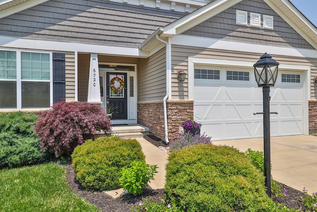 6520 Cannondale Dr, Burlington, KY 41005 - doorway to property with an attached garage, stone siding, and concrete driveway