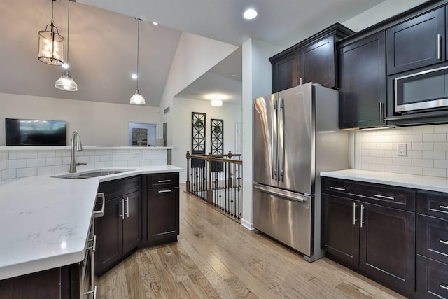 6520 Cannondale Dr, Burlington, KY 41005 - kitchen featuring stainless steel appliances, a sink, light wood-style floors, tasteful backsplash, and pendant lighting