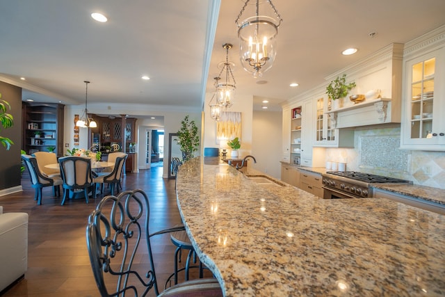 101 Harbor Greene Dr Unit W705, Bellevue, KY 41073 - kitchen featuring a chandelier, stainless steel stove, a sink, light stone counters, and ornamental molding