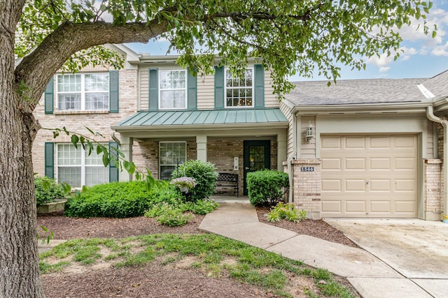 1546 Taramore Dr Unit 203, Florence, KY 41042 - view of front of property with brick siding, a porch, a garage, driveway, and a standing seam roof