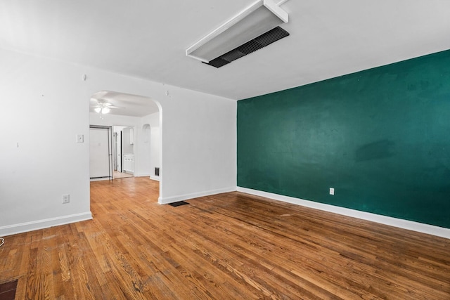 309 Hawthorne St, Covington, KY 41014 - unfurnished room featuring arched walkways, wood finished floors, baseboards, and a ceiling fan