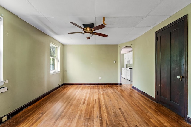 309 Hawthorne St, Covington, KY 41014 - unfurnished room with a ceiling fan, arched walkways, wood-type flooring, and baseboards