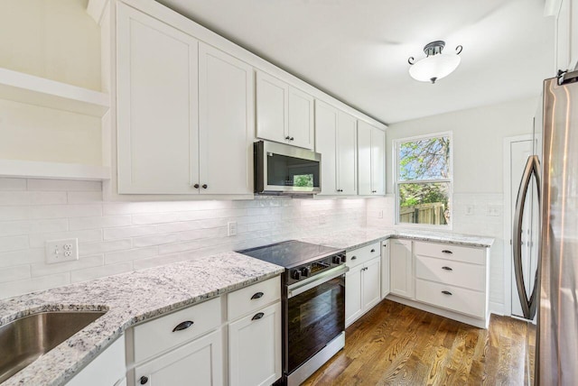 831 Linden Ave, Newport, KY 41071 - kitchen featuring appliances with stainless steel finishes, open shelves, white cabinets, dark wood-type flooring, and decorative backsplash