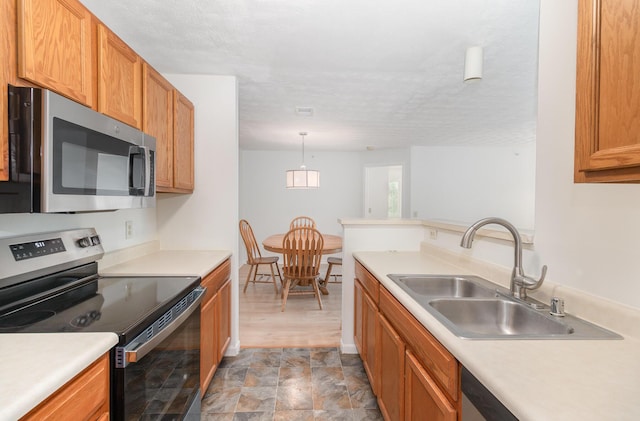 2308 Sawmill Ct Unit 207, Burlington, KY 41005 - kitchen featuring appliances with stainless steel finishes, a sink, stone finish flooring, light countertops, and hanging light fixtures
