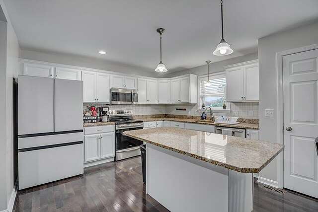 10658 Blooming Ct, Independence, KY 41051 - kitchen with appliances with stainless steel finishes, recessed lighting, white cabinets, decorative backsplash, and dark wood-style floors