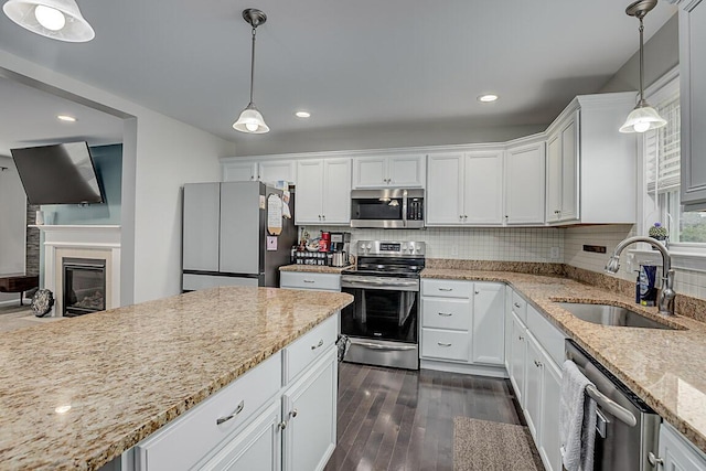 10658 Blooming Ct, Independence, KY 41051 - kitchen featuring appliances with stainless steel finishes, dark wood-type flooring, white cabinetry, light stone counters, and tasteful backsplash