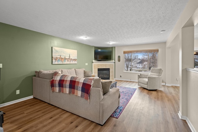 10335 Mackay Ct, Independence, KY 41051 - living area with wood finished floors, a tile fireplace, baseboards, and a textured ceiling