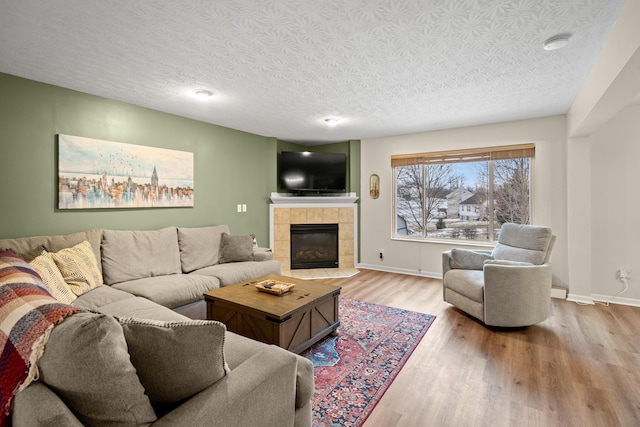 10335 Mackay Ct, Independence, KY 41051 - living room with wood finished floors, a fireplace, a textured ceiling, and baseboards
