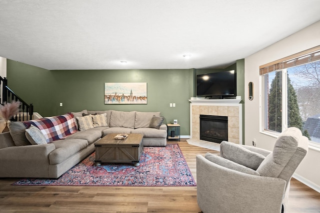 10335 Mackay Ct, Independence, KY 41051 - living room with stairway, wood finished floors, a tiled fireplace, and baseboards