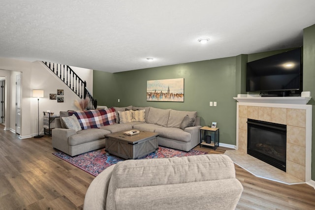 10335 Mackay Ct, Independence, KY 41051 - living room with wood finished floors, stairway, a tile fireplace, and baseboards