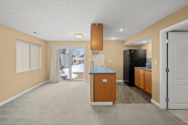 10335 Mackay Ct, Independence, KY 41051 - kitchen with freestanding refrigerator, dark colored carpet, brown cabinets, baseboards, and a textured ceiling