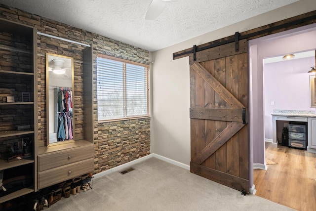 10335 Mackay Ct, Independence, KY 41051 - unfurnished bedroom featuring a barn door, baseboards, ceiling fan, and a textured ceiling