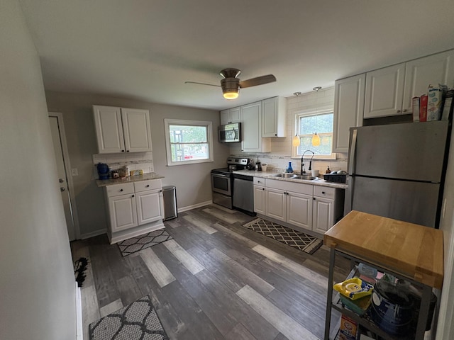 107 W 1st St, Silver Grove, KY 41085 - kitchen with stainless steel appliances, light countertops, decorative backsplash, dark wood-type flooring, and ceiling fan