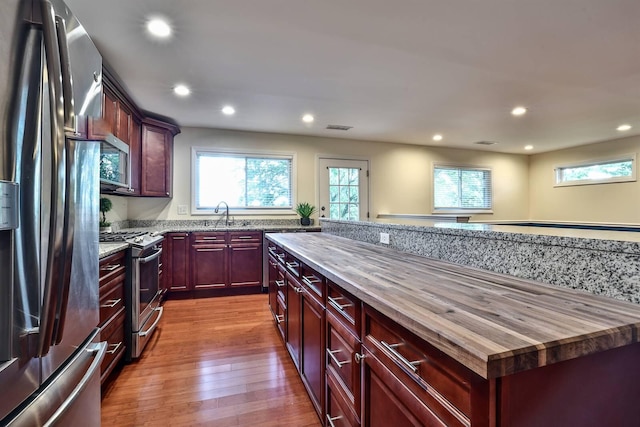 724 Dudley Rd, Edgewood, KY 41017 - kitchen featuring stainless steel appliances, dark brown cabinets, butcher block counters, recessed lighting, and wood finished floors