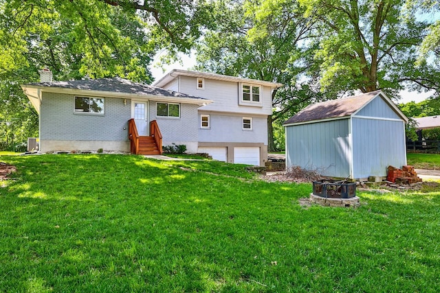 724 Dudley Rd, Edgewood, KY 41017 - rear view of property featuring a garage, a chimney, an outdoor fire pit, and a yard