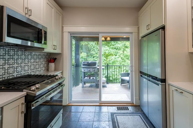 386 Linden Ave, Southgate, KY 41071 - kitchen featuring appliances with stainless steel finishes, backsplash, white cabinetry, and light countertops