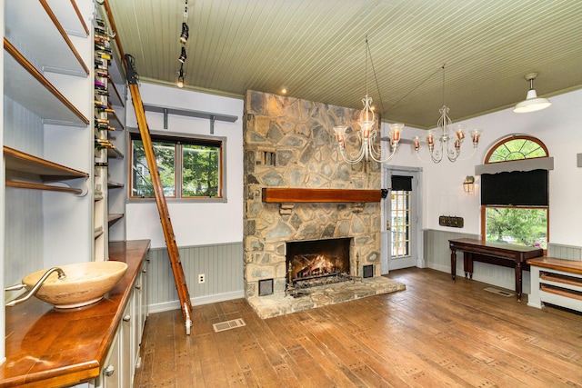 34 Ridge Rd, Fort Mitchell, KY 41011 - living room with wood-type flooring, a stone fireplace, wainscoting, healthy amount of natural light, and track lighting