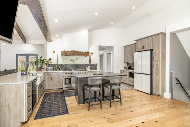 2003 Pieck Dr, Fort Wright, KY 41011 - kitchen featuring appliances with stainless steel finishes, lofted ceiling, a breakfast bar area, light wood-type flooring, and decorative backsplash