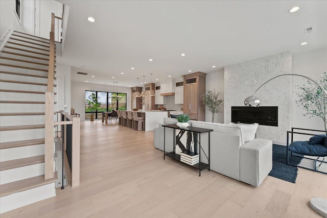 76 W 13th St Unit 34, Newport, KY 41071 - living room featuring light wood-type flooring, recessed lighting, a premium fireplace, and stairway