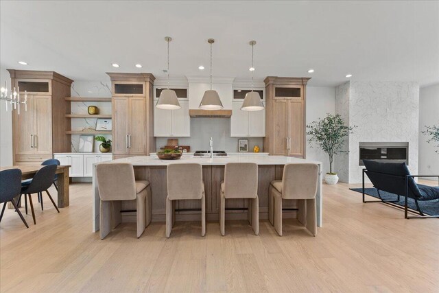 76 W 13th St Unit 34, Newport, KY 41071 - kitchen with open shelves, light countertops, an island with sink, light wood-style floors, and recessed lighting