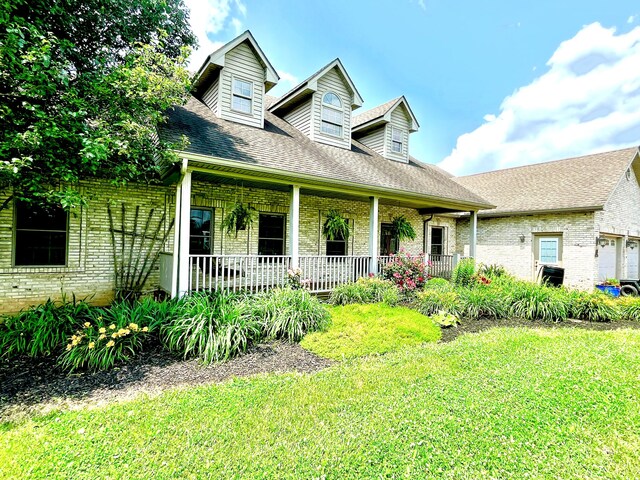 3745 Sweet Owen Rd, Owenton, KY 40359 - new england style home featuring brick siding, covered porch, a front lawn, a shingled roof, and a garage