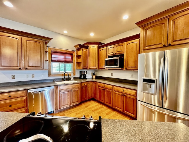 3745 Sweet Owen Rd, Owenton, KY 40359 - kitchen featuring appliances with stainless steel finishes, a sink, brown cabinetry, light wood-style floors, and dark countertops