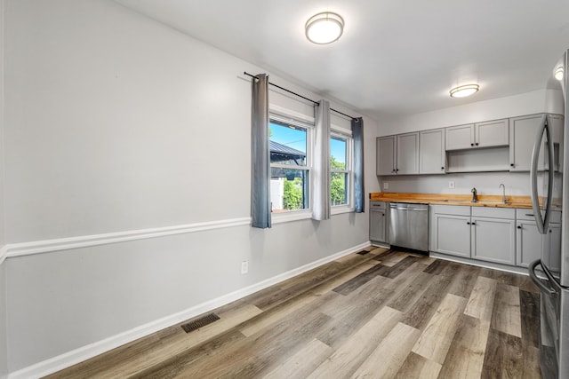 3771 Feather Ln, Elsmere, KY 41018 - kitchen featuring appliances with stainless steel finishes, wooden counters, gray cabinets, dark wood-style floors, and open shelves