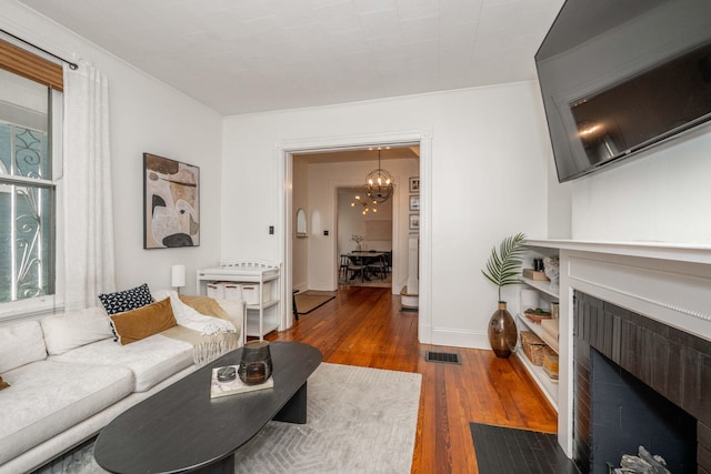 1915 Scott St, Covington, KY 41014 - living area featuring a fireplace with flush hearth, dark wood-style floors, and a chandelier