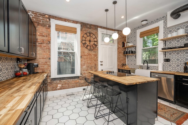 1915 Scott St, Covington, KY 41014 - kitchen with butcher block counters, stainless steel dishwasher, open shelves, a kitchen breakfast bar, and backsplash