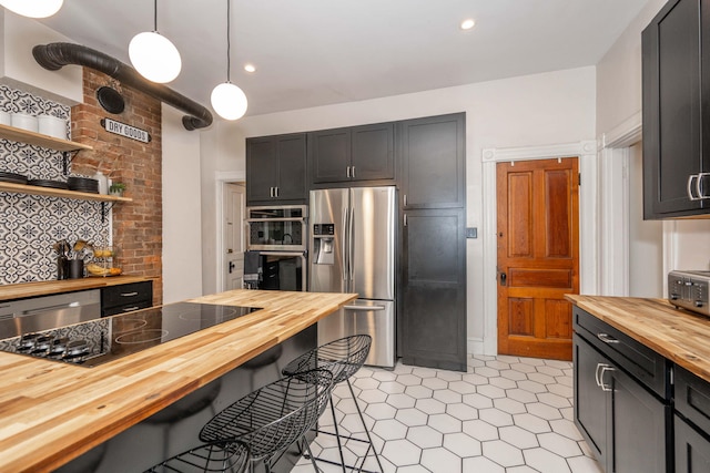 1915 Scott St, Covington, KY 41014 - kitchen featuring wood counters, appliances with stainless steel finishes, backsplash, a kitchen breakfast bar, and hanging light fixtures