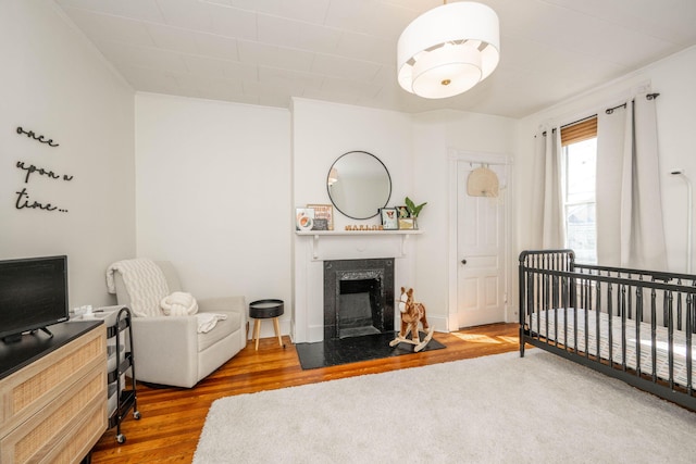 1915 Scott St, Covington, KY 41014 - bedroom featuring wood finished floors, a fireplace, a crib, and ornamental molding