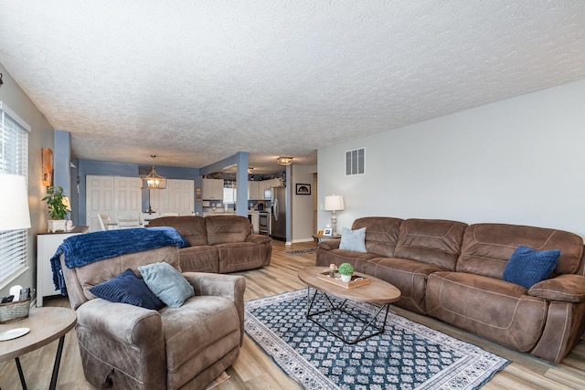 2246 Algiers St, Union, KY 41091 - living room with light wood-type flooring, a textured ceiling, and healthy amount of natural light