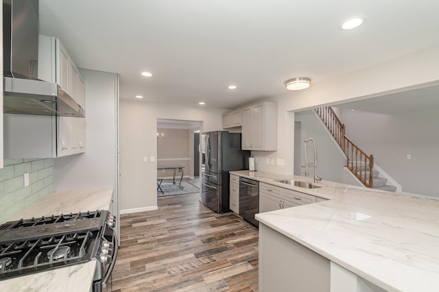 2282 Berkshire Ct, Florence, KY 41042 - kitchen with stainless steel appliances, wall chimney range hood, light stone counters, wood finished floors, and decorative backsplash