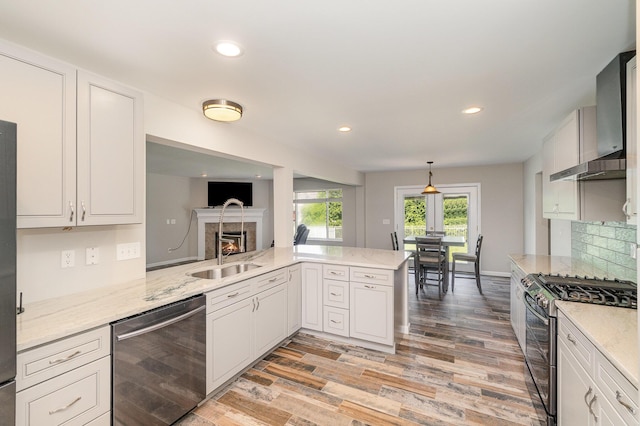2282 Berkshire Ct, Florence, KY 41042 - kitchen with appliances with stainless steel finishes, a tile fireplace, light stone counters, light wood finished floors, and recessed lighting