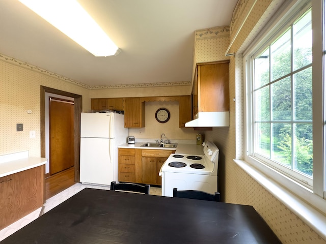3141 Riggs Ave, Erlanger, KY 41018 - kitchen featuring white appliances, wallpapered walls, under cabinet range hood, light countertops, and brown cabinetry