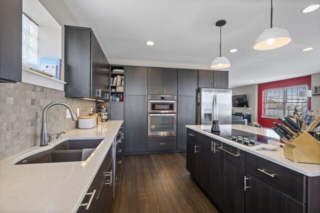202 W 13th St, Newport, KY 41071 - kitchen featuring appliances with stainless steel finishes, dark wood-type flooring, decorative light fixtures, backsplash, and a center island