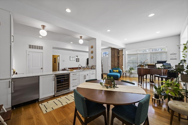 202 W 13th St, Newport, KY 41071 - kitchen with beverage cooler, white cabinets, light wood finished floors, recessed lighting, and light countertops