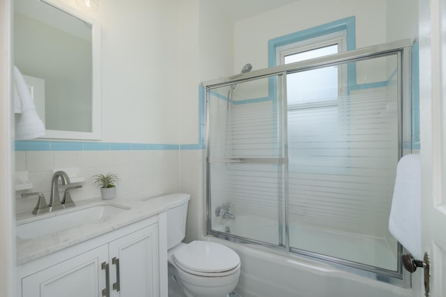 22 Woodland Pl, Fort Thomas, KY 41075 - bathroom with vanity, combined bath / shower with glass door, a wainscoted wall, and tile walls