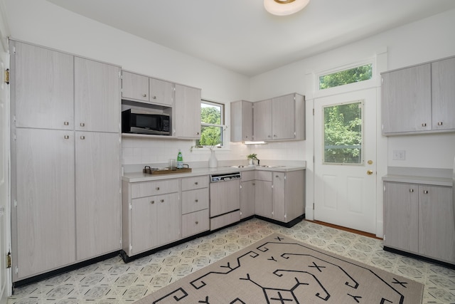 22 Woodland Pl, Fort Thomas, KY 41075 - kitchen with dishwasher, stainless steel microwave, light floors, light countertops, and decorative backsplash