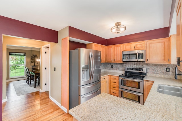 8202 Heatherwood Dr, Florence, KY 41042 - kitchen featuring stainless steel appliances, decorative backsplash, light wood-type flooring, light brown cabinetry, and a peninsula