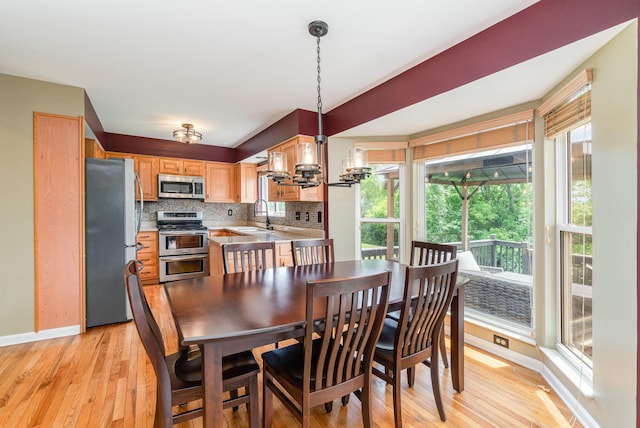 8202 Heatherwood Dr, Florence, KY 41042 - dining space with light wood-style flooring, plenty of natural light, and a chandelier