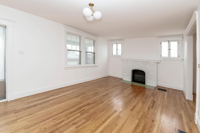 61 Biehl St, Newport, KY 41071 - unfurnished living room featuring light wood-style flooring and a brick fireplace