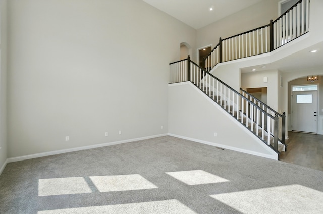 3226 Chloe Ct, Hebron, KY 41048 - unfurnished living room featuring arched walkways, stairs, carpet flooring, a high ceiling, and recessed lighting