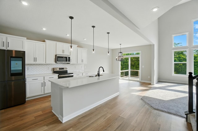 3226 Chloe Ct, Hebron, KY 41048 - kitchen with stainless steel appliances, wood finished floors, backsplash, light countertops, and white cabinets