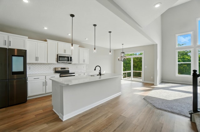 3226 Chloe Ct, Hebron, KY 41048 - kitchen featuring appliances with stainless steel finishes, wood finished floors, backsplash, white cabinets, and recessed lighting